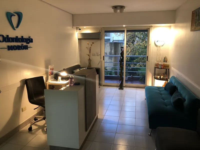La sala de espera, con un sillón turquesa y un ventanal.